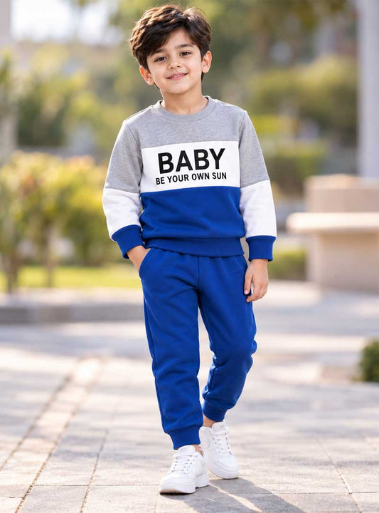Boy wearing blue grey and white winter tracksuit outdoors
